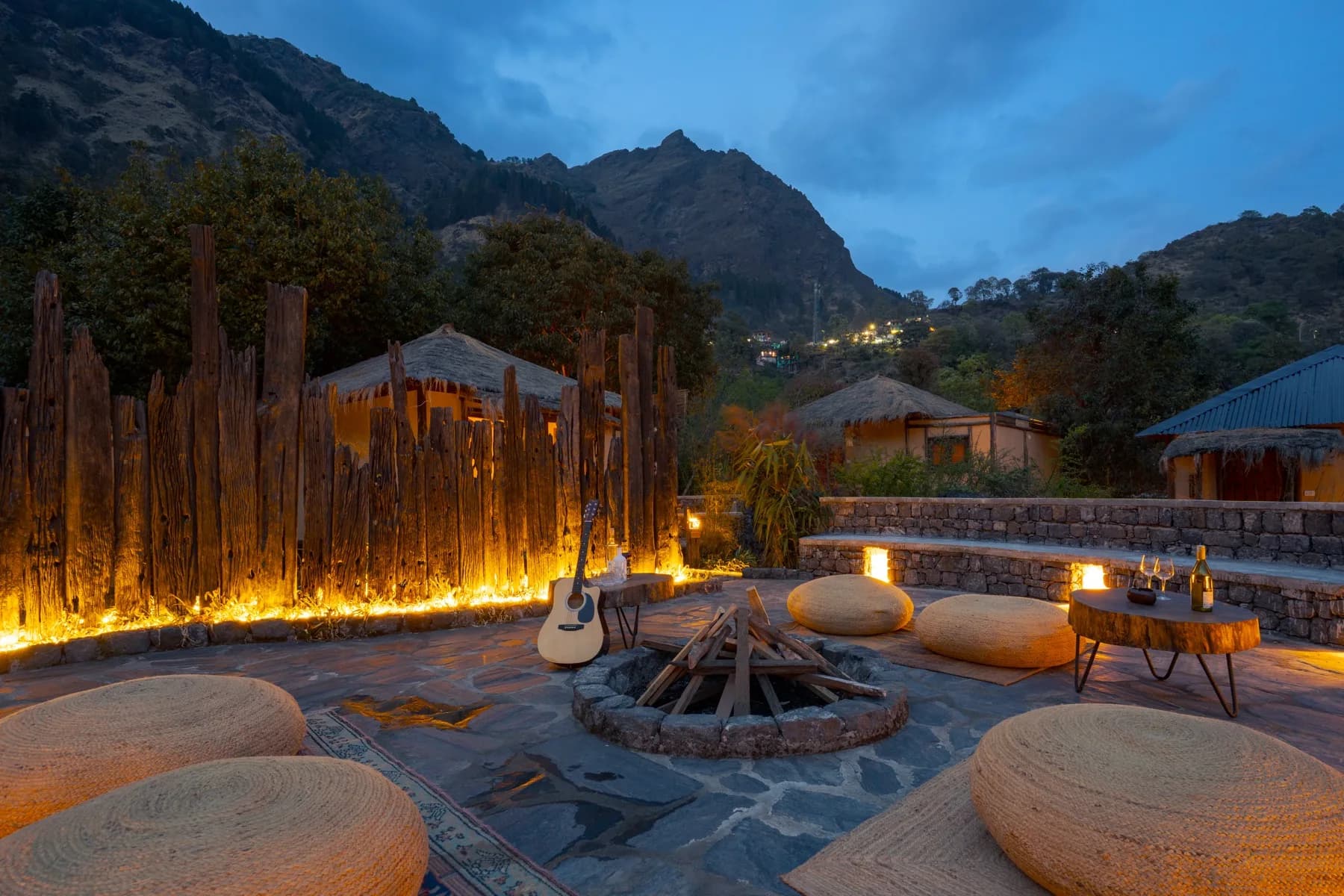 Firepit gathering with guitar and mountain backdrop in the evening