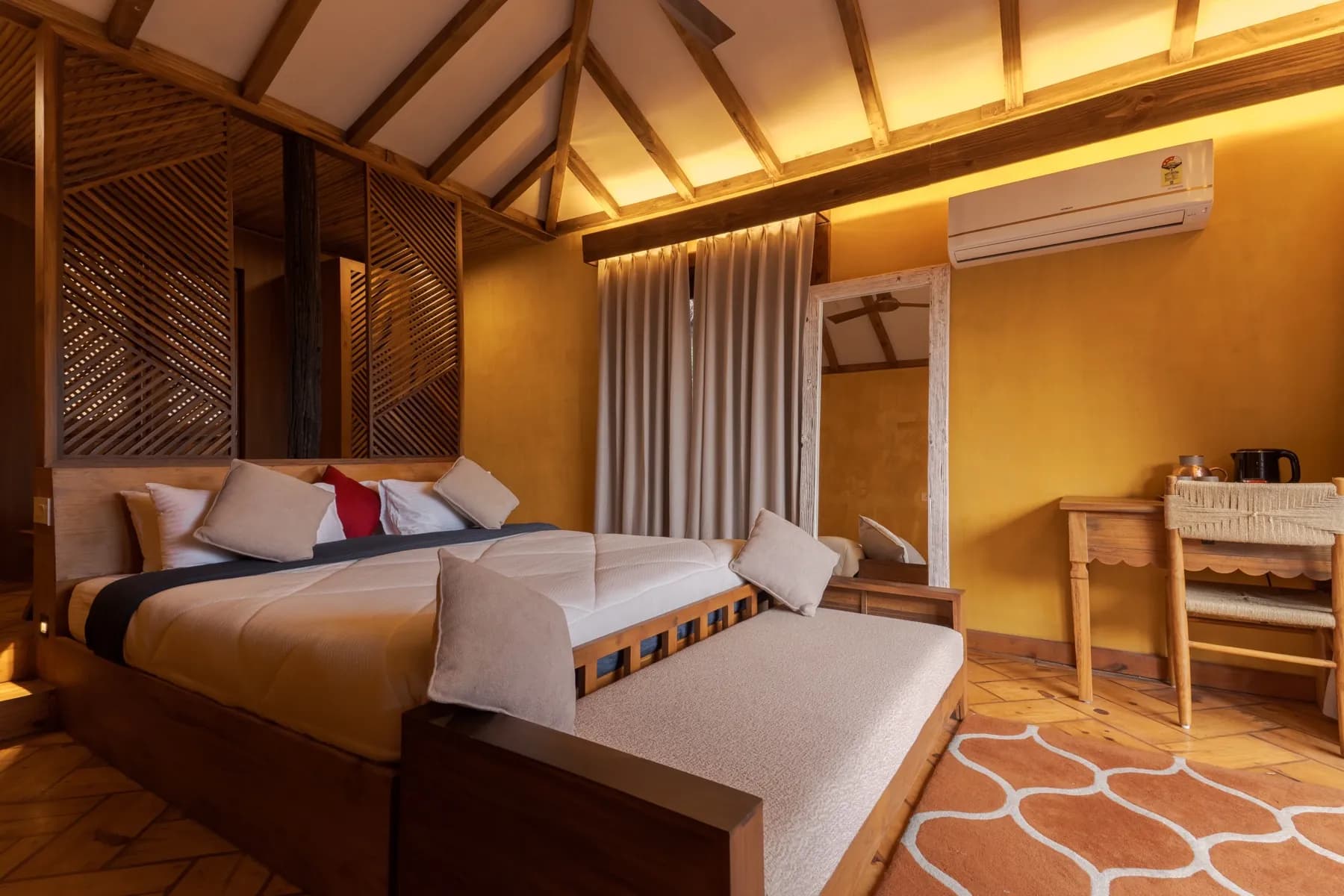 Cozy guest room corner with desk and tree-view balcony door