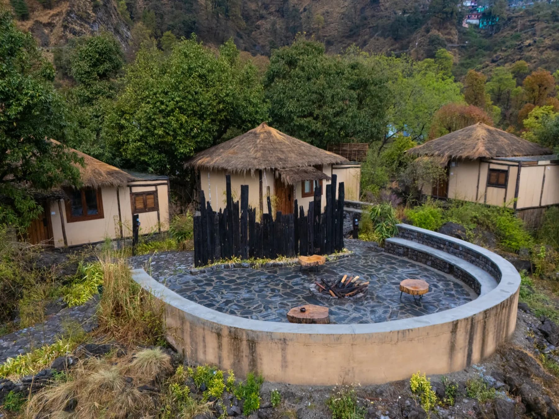 Kaansya cottages with circular firepit and pine forest behind