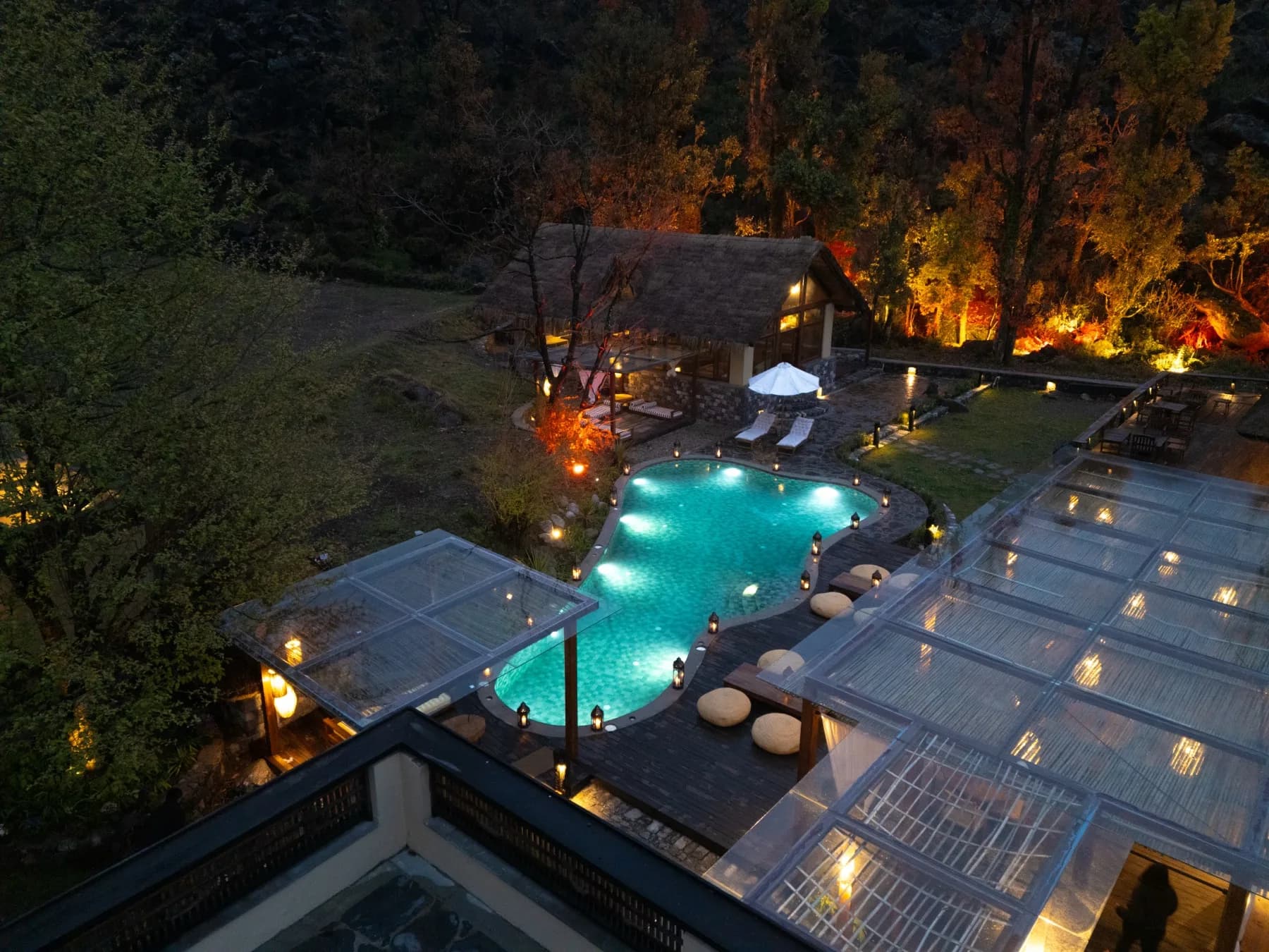 Aerial nighttime view of the Kaansya pool area lit with warm lights