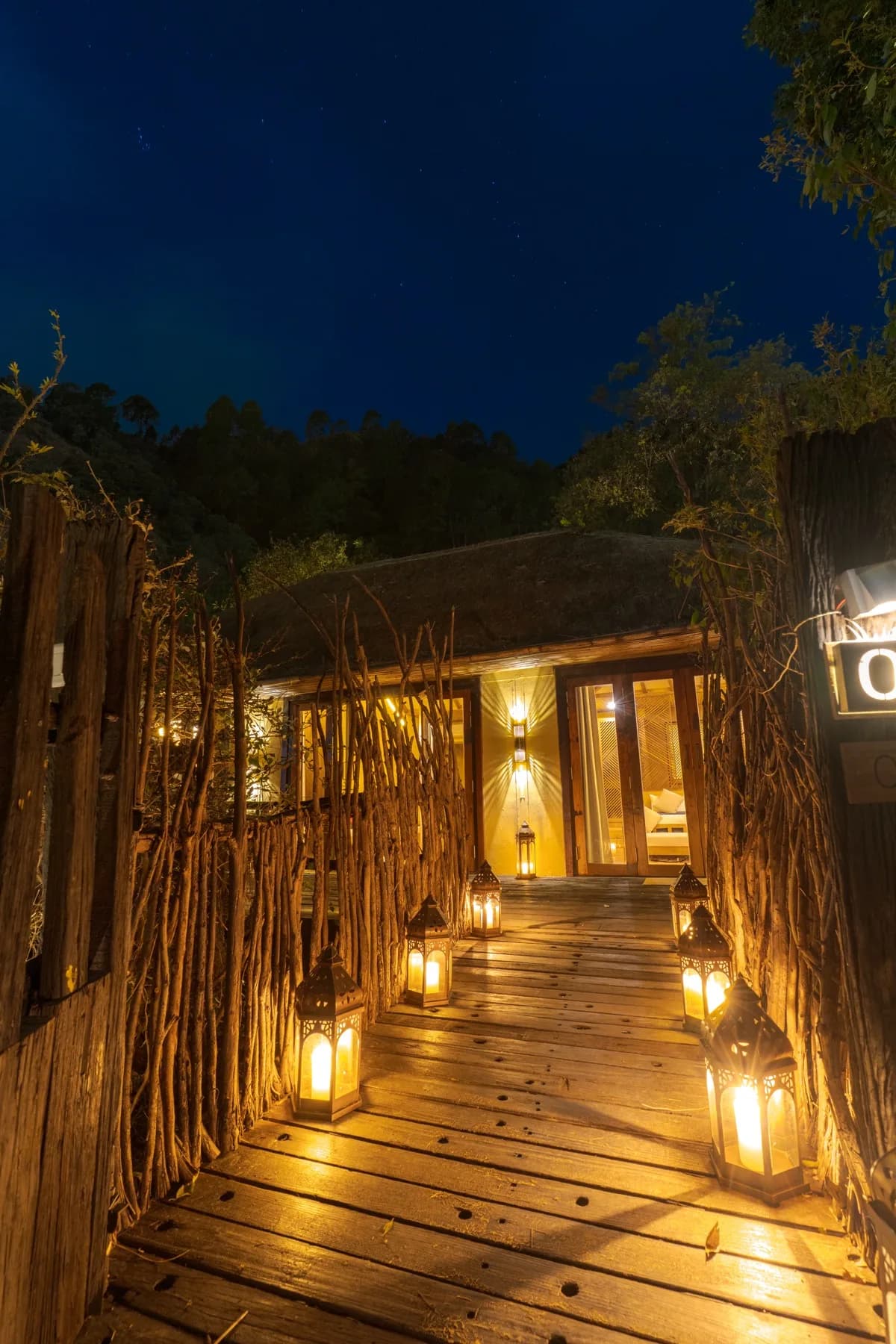 Lantern-lit walkway leading to a Kaansya villa at night